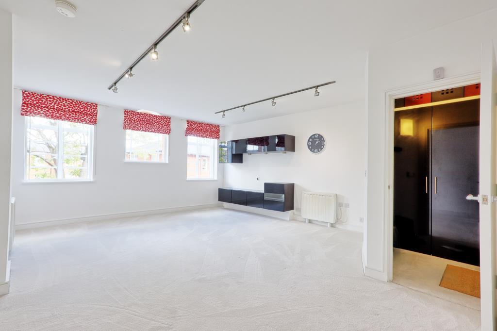 Carpeted living area with 3 windows and media cabi