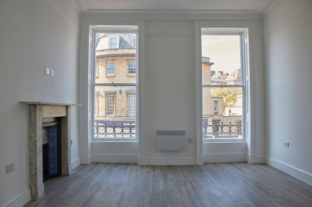 Bright and airy living room featuring large sas...