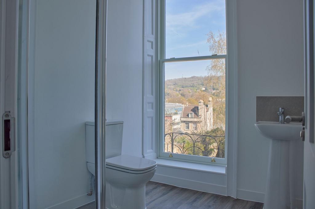 A bright and clean bathroom suite featuring a w...