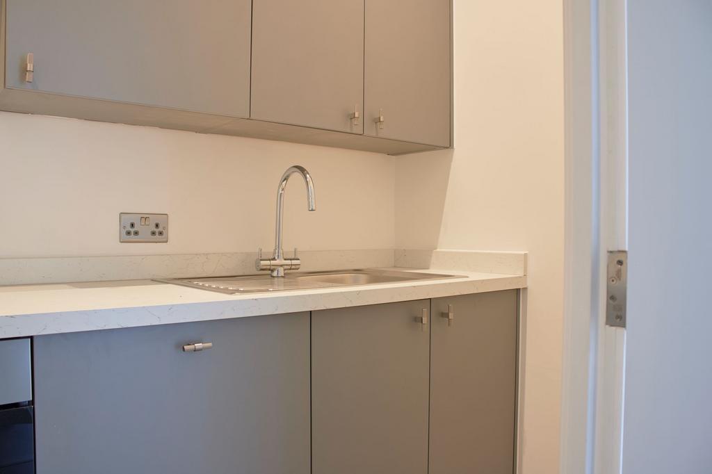 Modern kitchen with sleek grey cabinetry and a ...