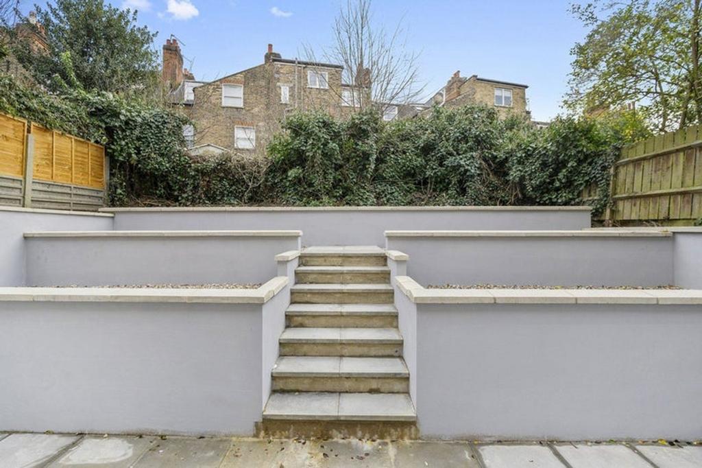 A well-maintained garden with stairs leading up...