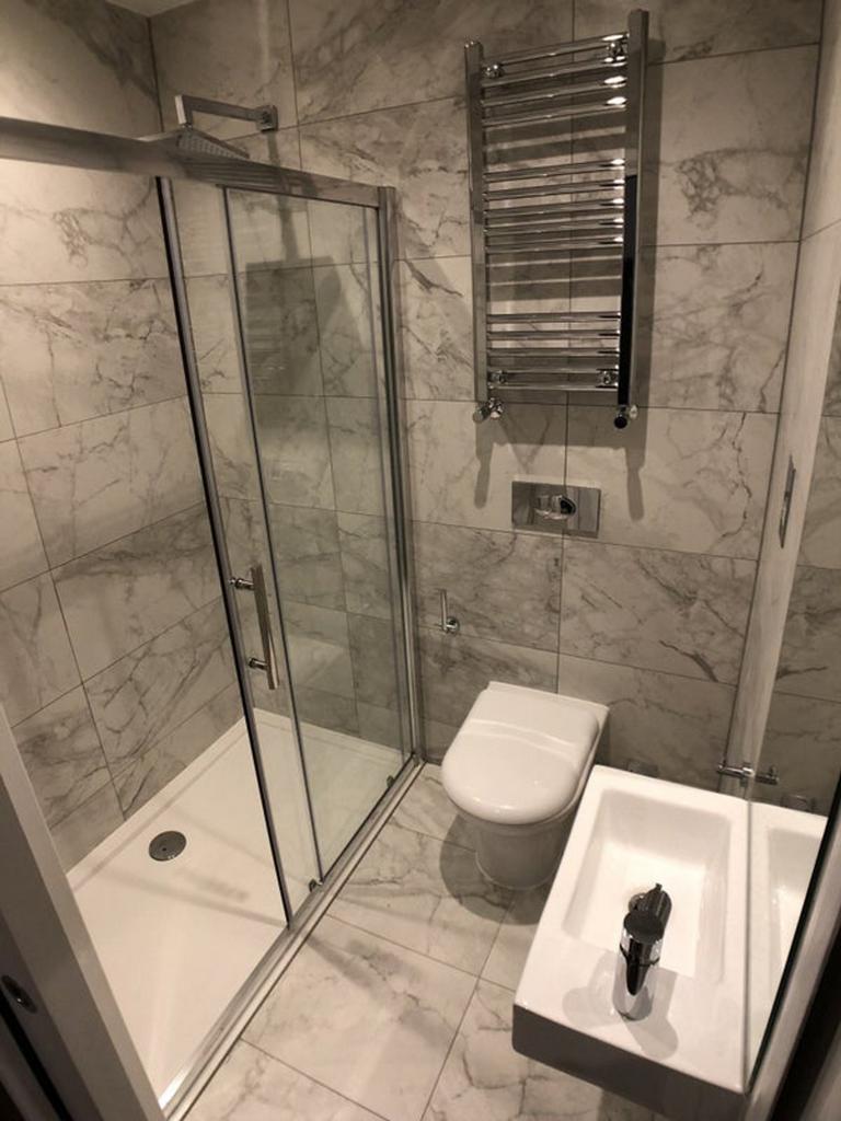 A clean and modern bathroom featuring a shower....