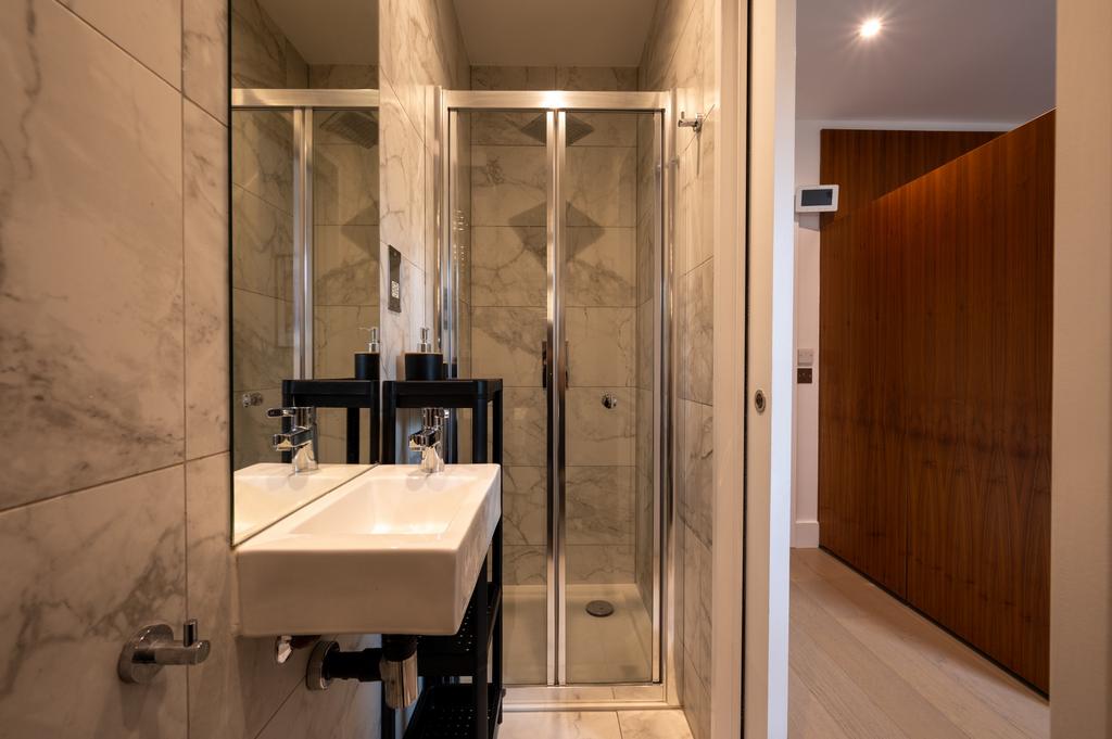 Modern bathroom featuring sleek marble wall til...
