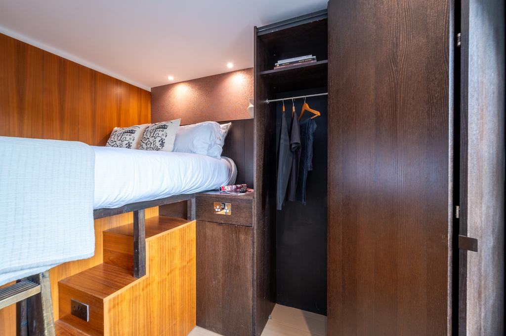 A stylish compact bedroom with a raised single ...