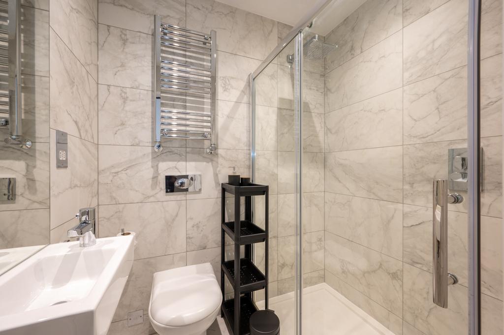 Modern bathroom with elegant marble-style tiled...