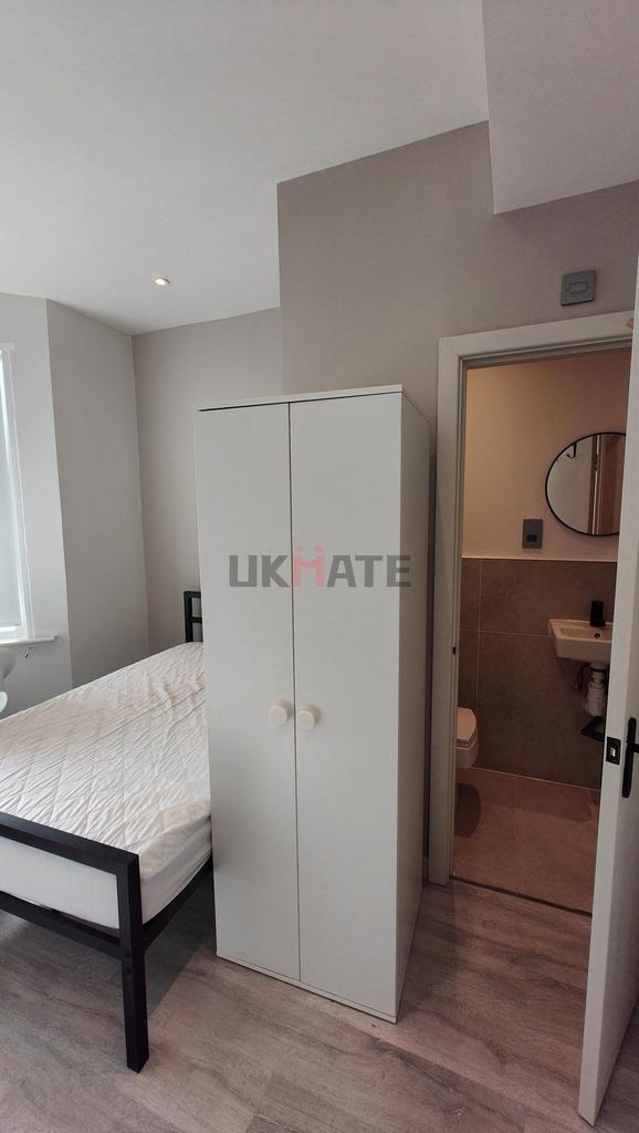 A compact yet inviting bedroom featuring a ward...
