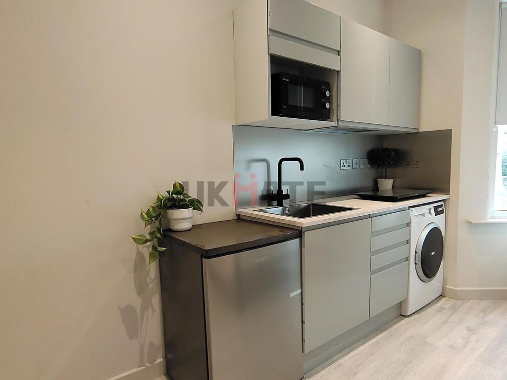 Modern kitchen featuring sleek cabinetry, a bui...