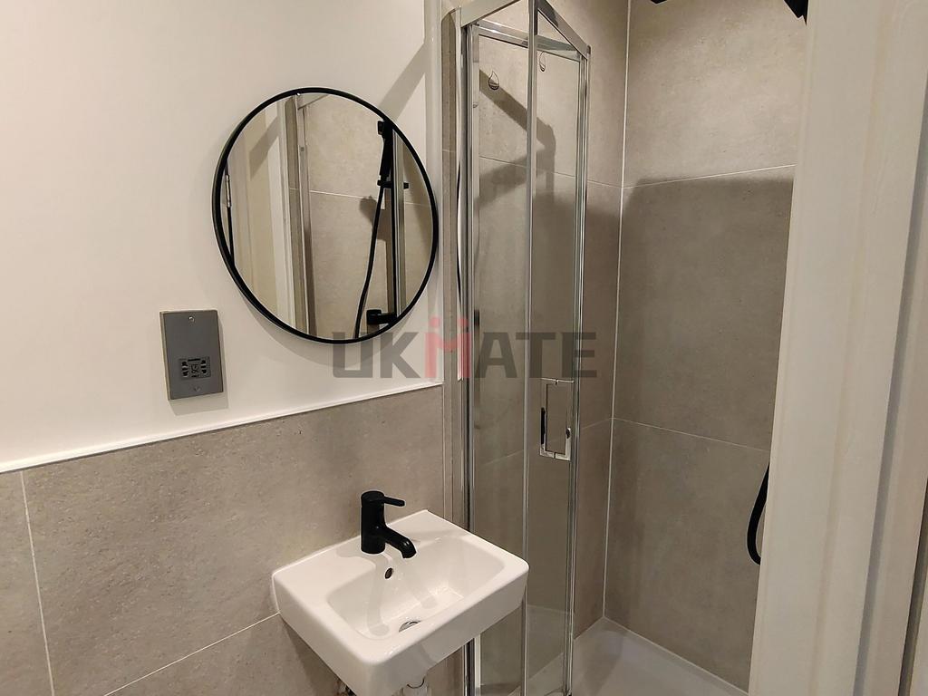 A modern, clean bathroom featuring a small sink...