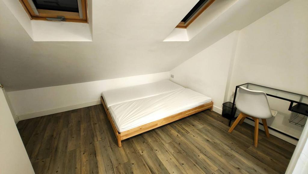 A cozy student&#39;s bedroom featuring a single bed...
