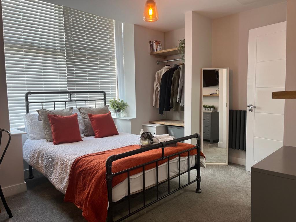 Bright and modern master bedroom featuring a st...