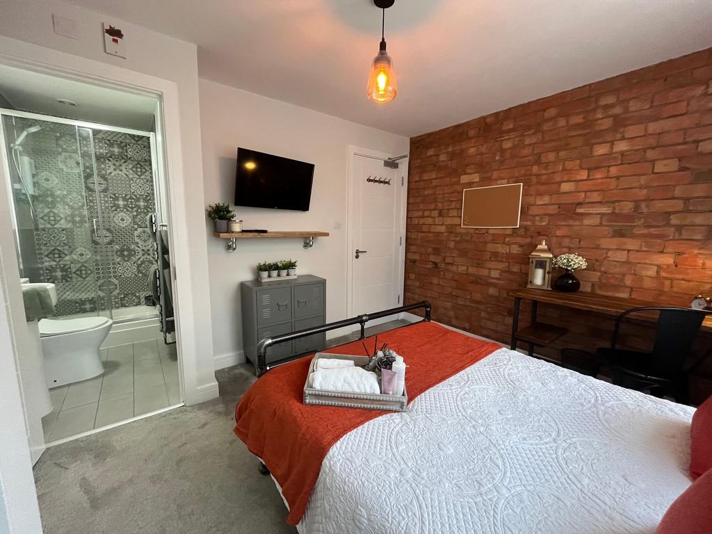 A stylish and inviting bedroom featuring a cozy...