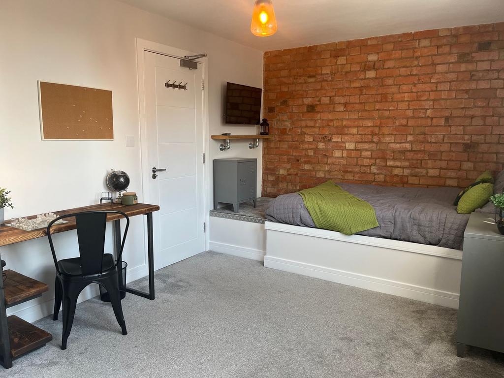 A modern, well-lit bedroom featuring a comforta...