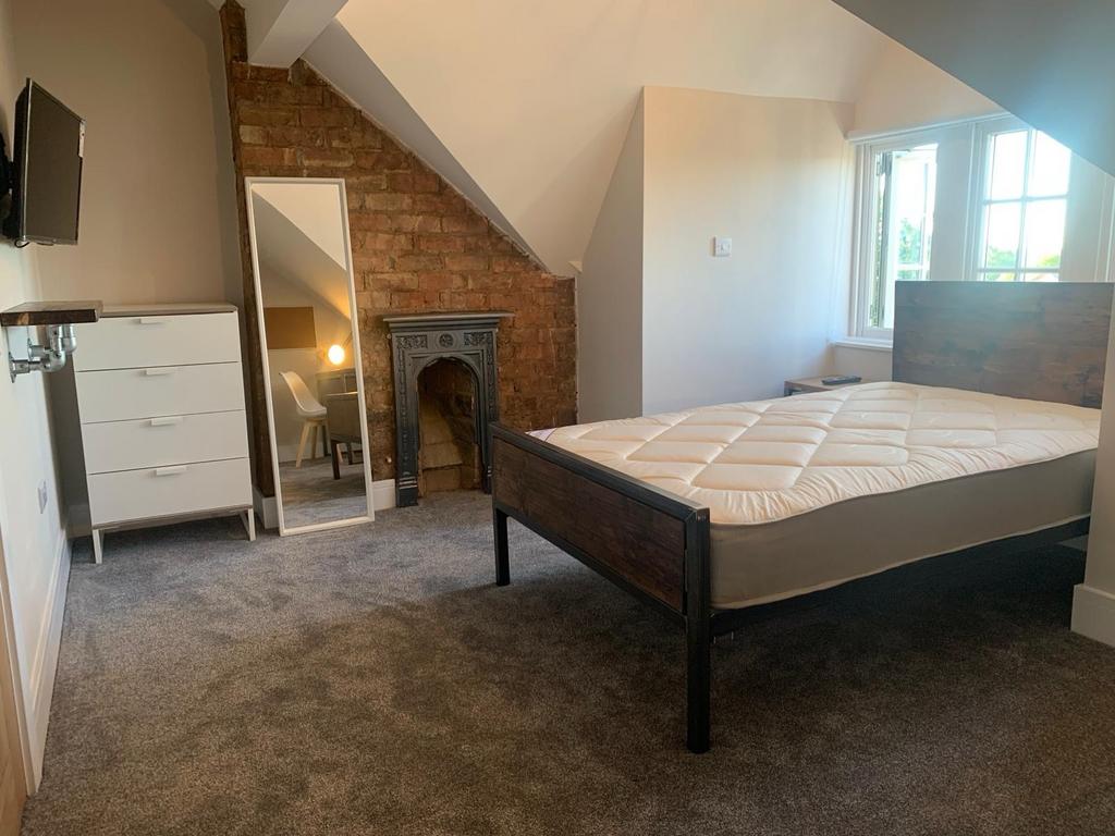 Spacious and well-lit bedroom featuring a sturd...