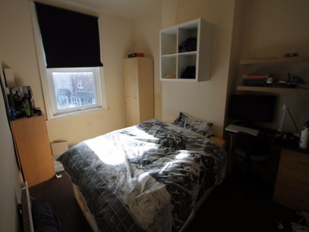 A well-lit bedroom featuring a spacious double ...