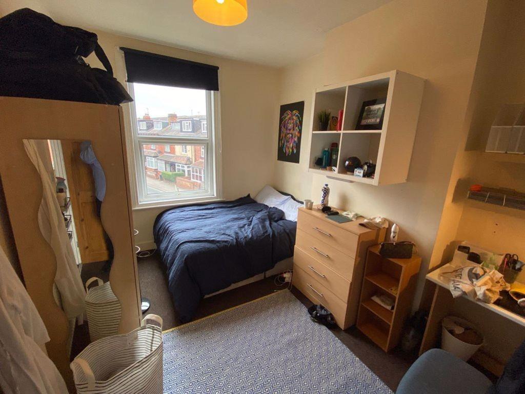 A cozy student bedroom featuring a double bed p...