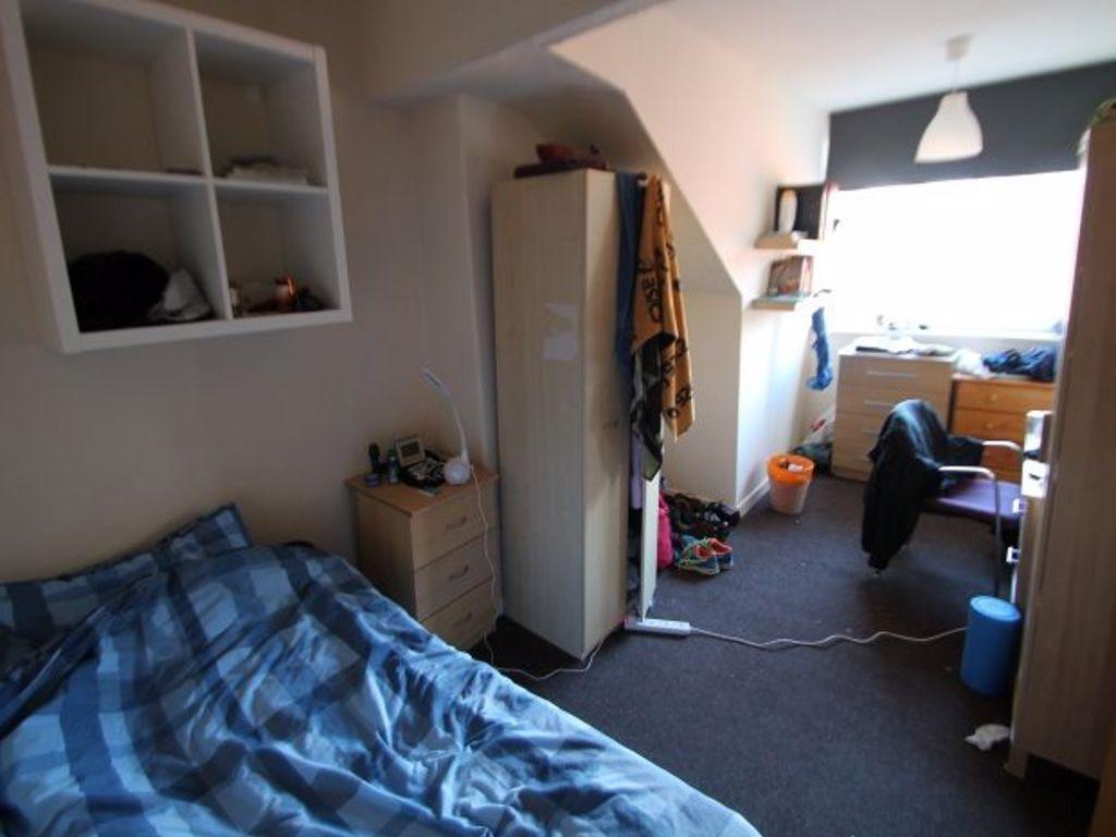 A cozy bedroom featuring a single bed with a bl...