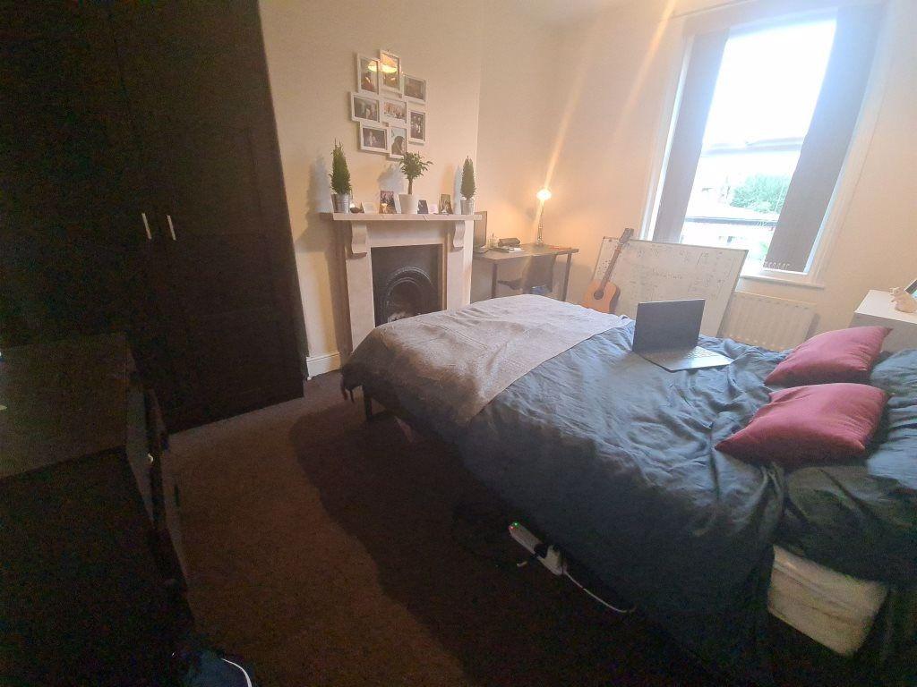 A cozy bedroom featuring a bed with pillows and...
