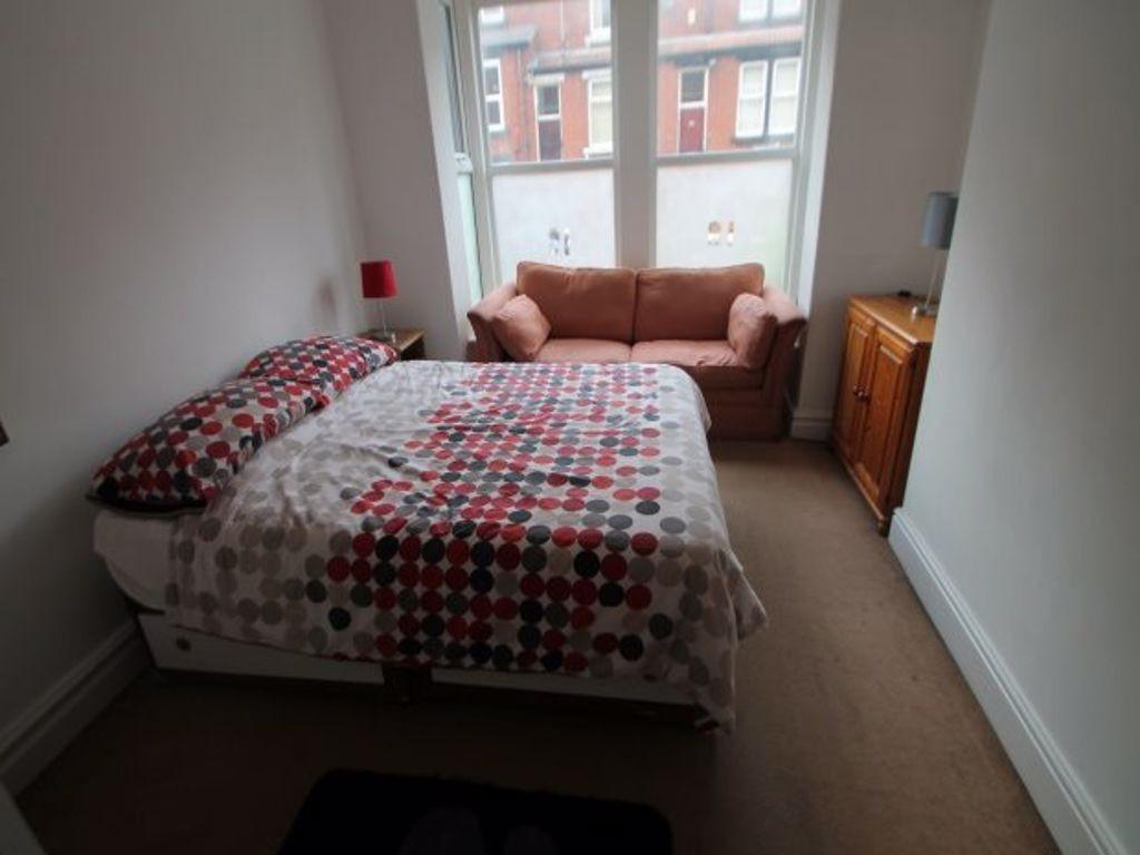 A cozy double bedroom with a double bed, a wind...