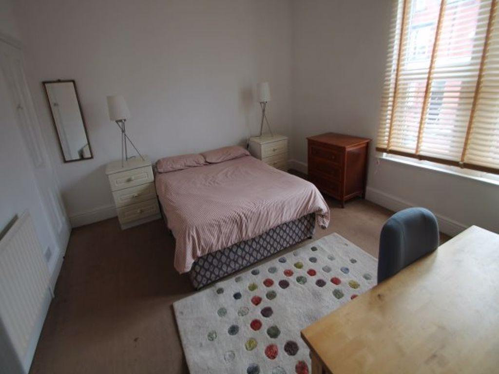 A spacious double bedroom featuring a large bed...