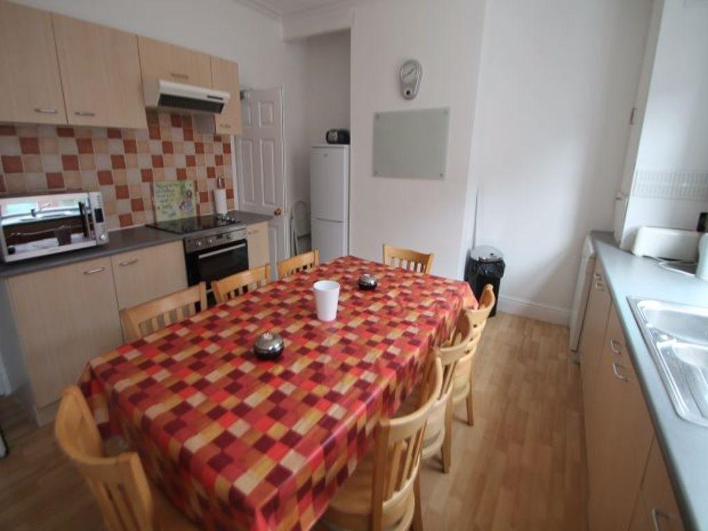 A well-maintained kitchen with a colorful tiled...