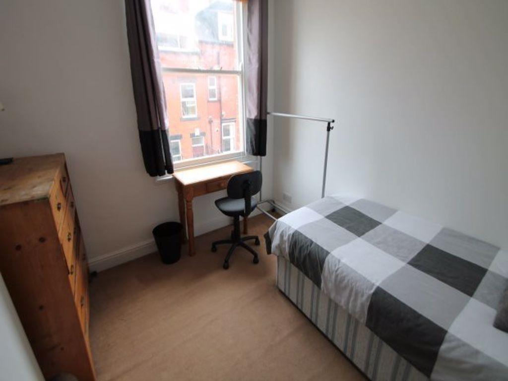 A cozy single bedroom featuring a neatly made b...
