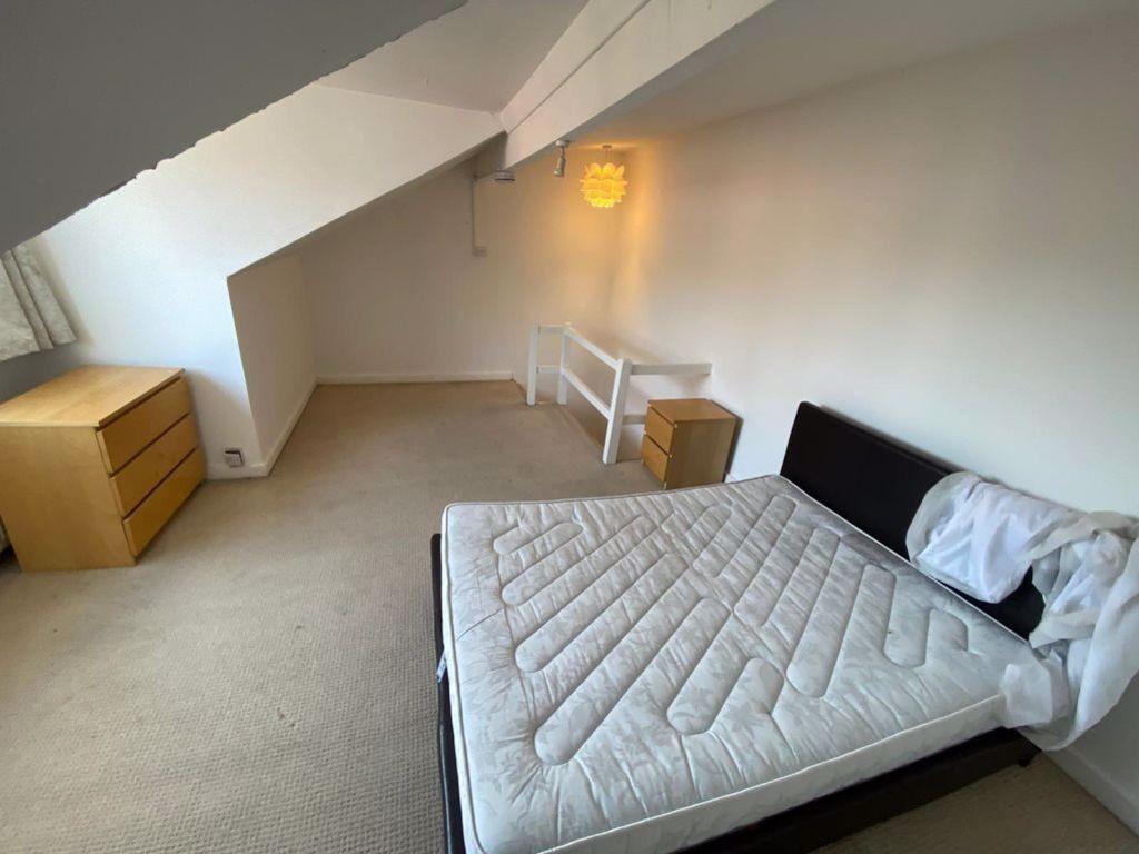 A bright and clean bedroom featuring a comforta...