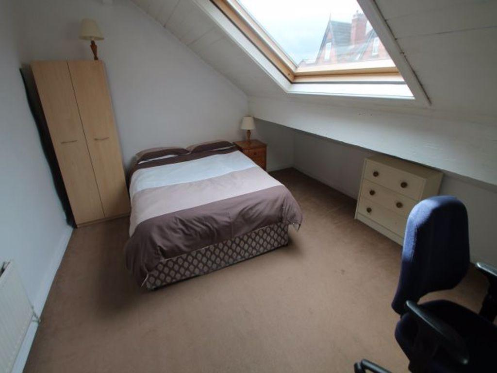 A cozy bedroom under a sloped roof with a doubl...