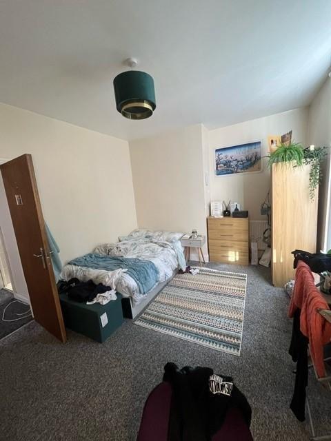 A cozy single bedroom with a comfortable bed, a...
