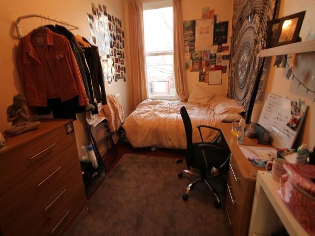 A cozy single bedroom featuring a bed situated ...