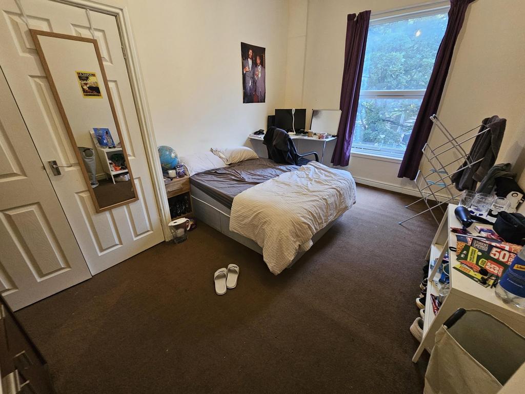 A cozy bedroom with a large window providing na...