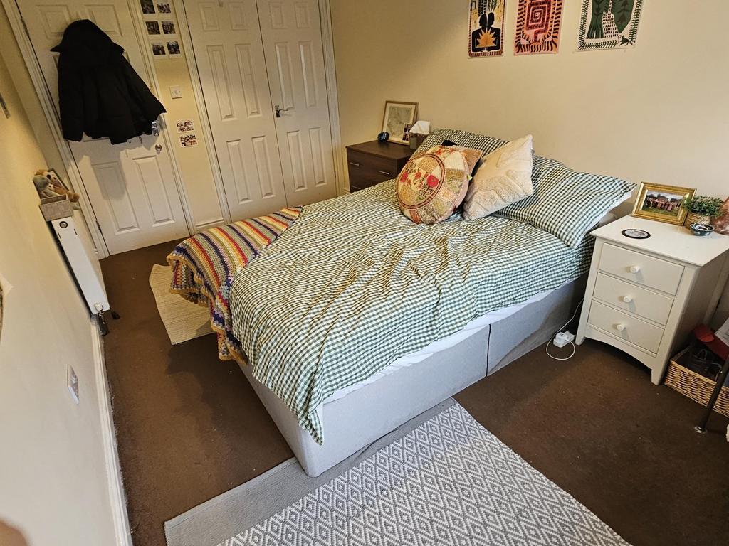 A cozy single bedroom featuring a well-made bed...