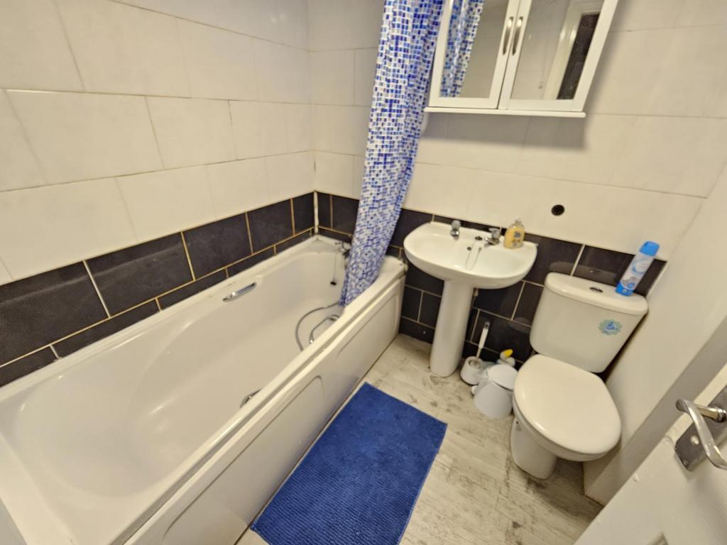 A well-maintained bathroom featuring a bathtub ...