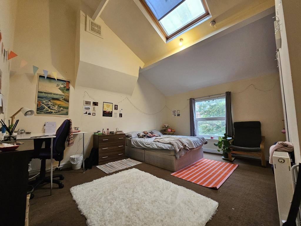 Spacious master bedroom featuring a large bed, ...