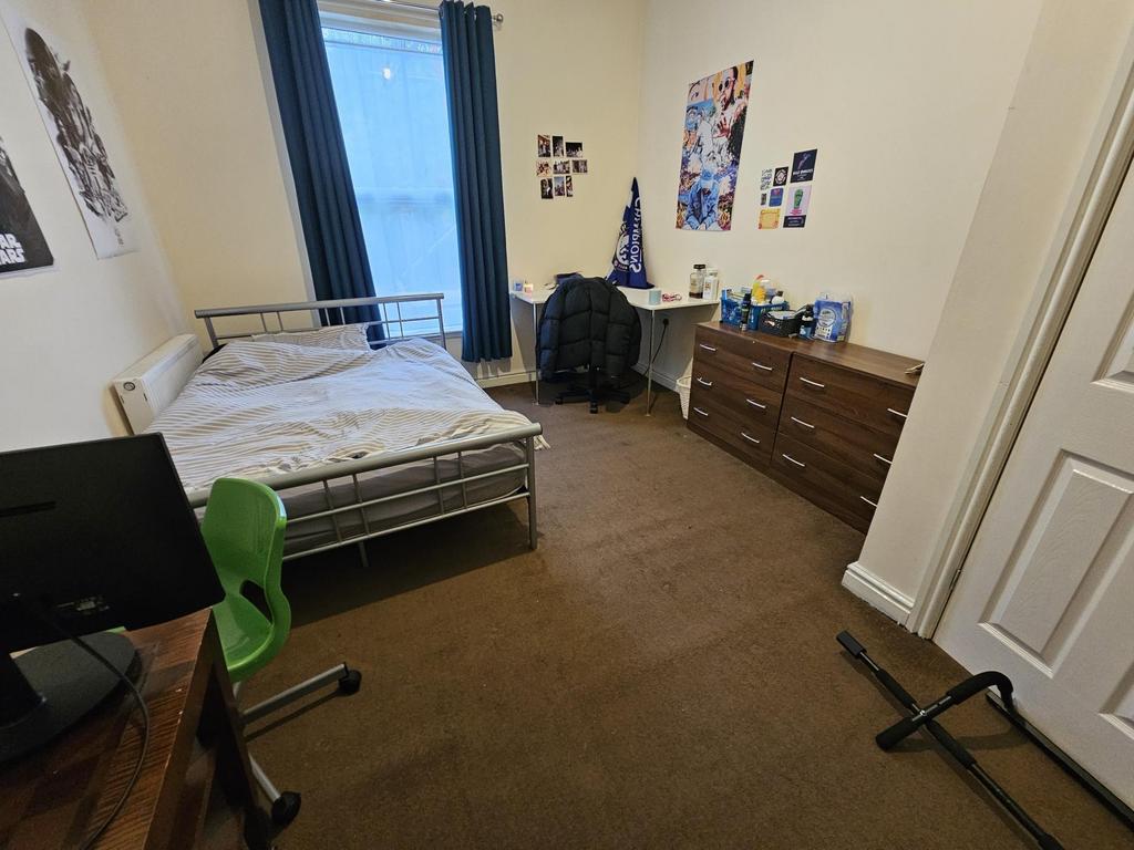 A cozy student bedroom featuring a single bed, ...