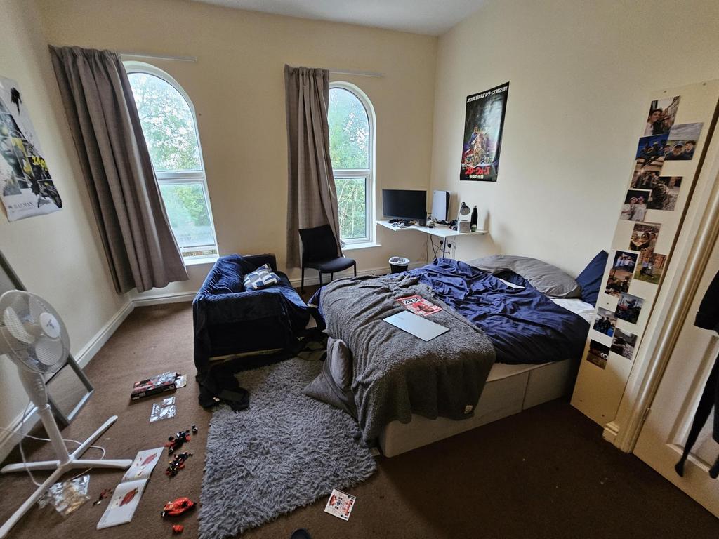 A cozy bedroom featuring a large bed, natural l...