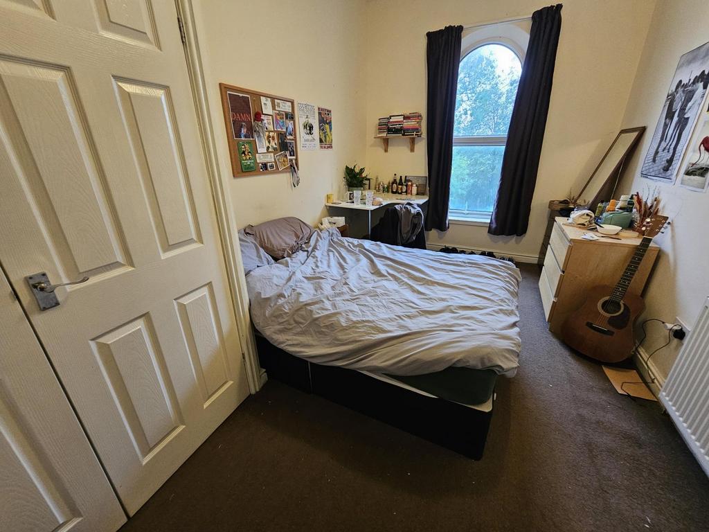 A spacious master bedroom with a comfortable do...