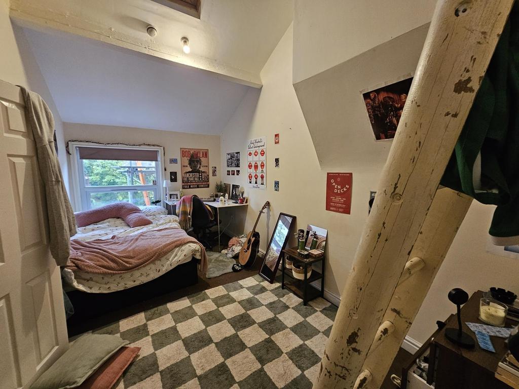 A cozy bedroom with a large window filling the ...