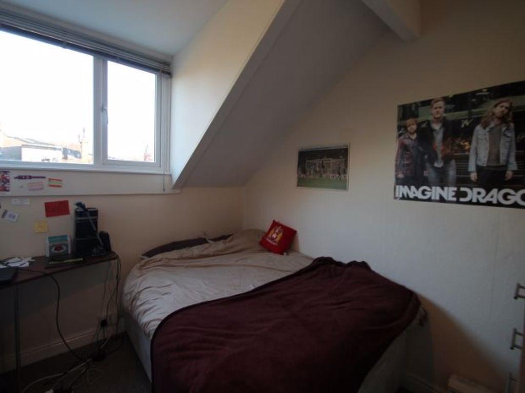 A cozy bedroom featuring a double bed, a window...