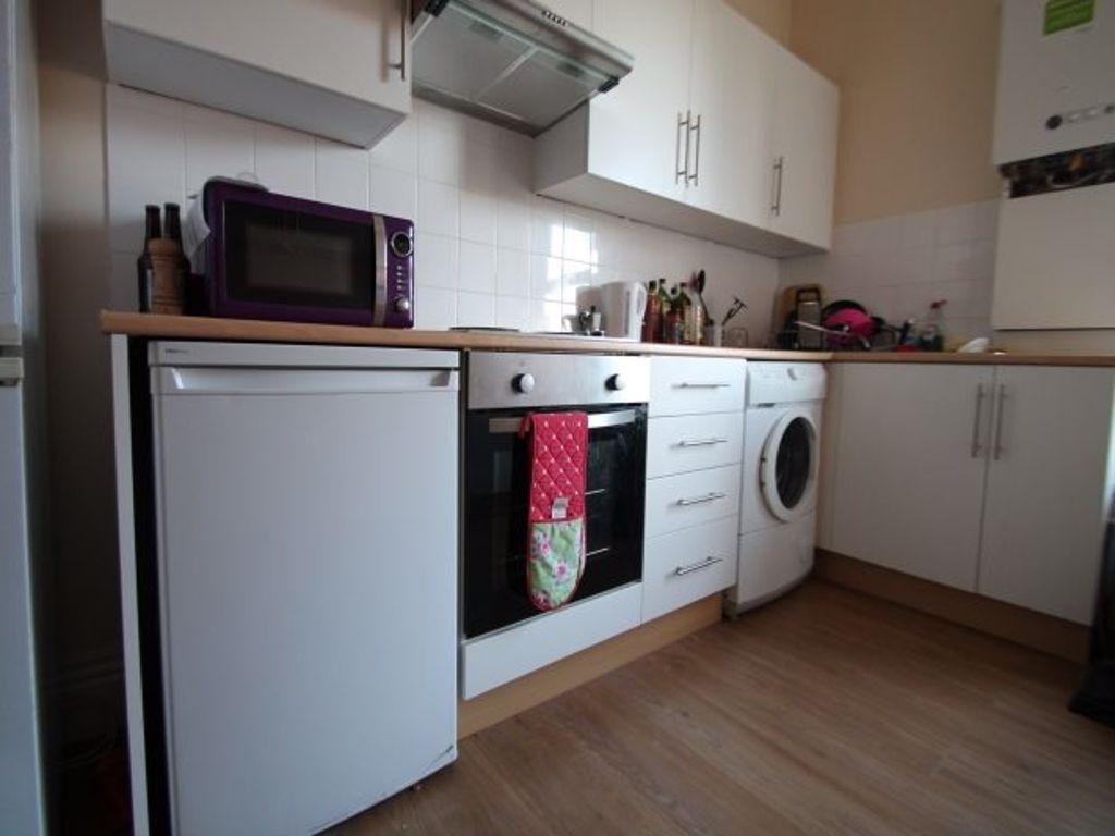 A modern and tidy kitchen with white cabinets, ...