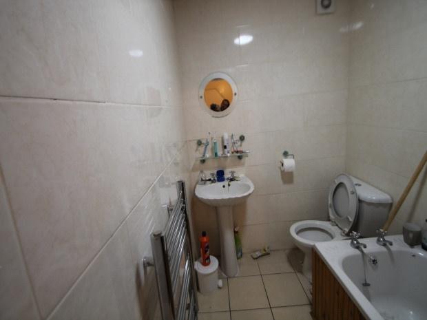A compact bathroom with a toilet and small sink...