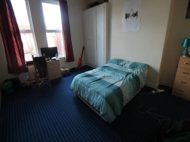 A cozy bedroom featuring a single bed with a bl...