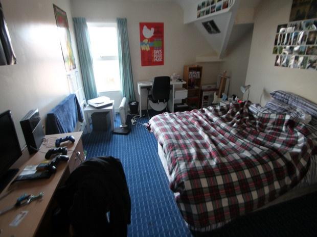 A cozy bedroom featuring a double bed with a ch...