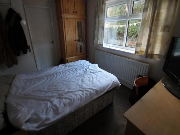 A cozy master bedroom with a neatly made bed, l...