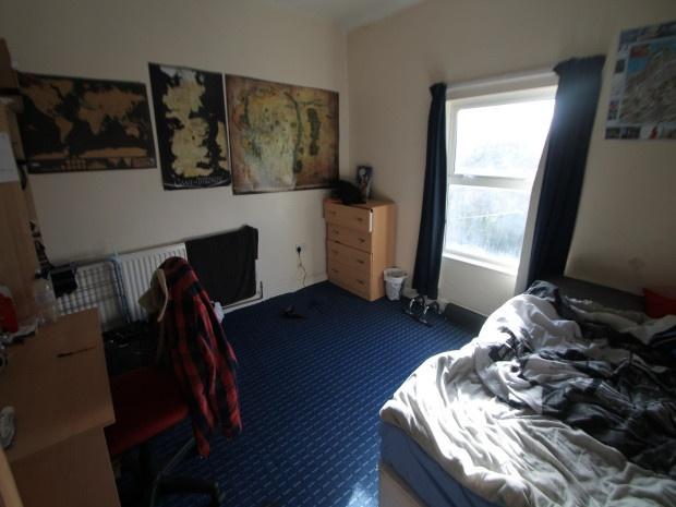 A cozy bedroom featuring a single bed with a cl...