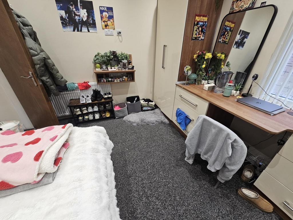 A well-maintained bedroom featuring a cozy bed ...