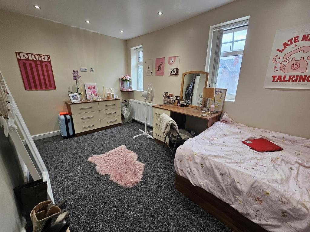 A bright and well-maintained bedroom featuring ...