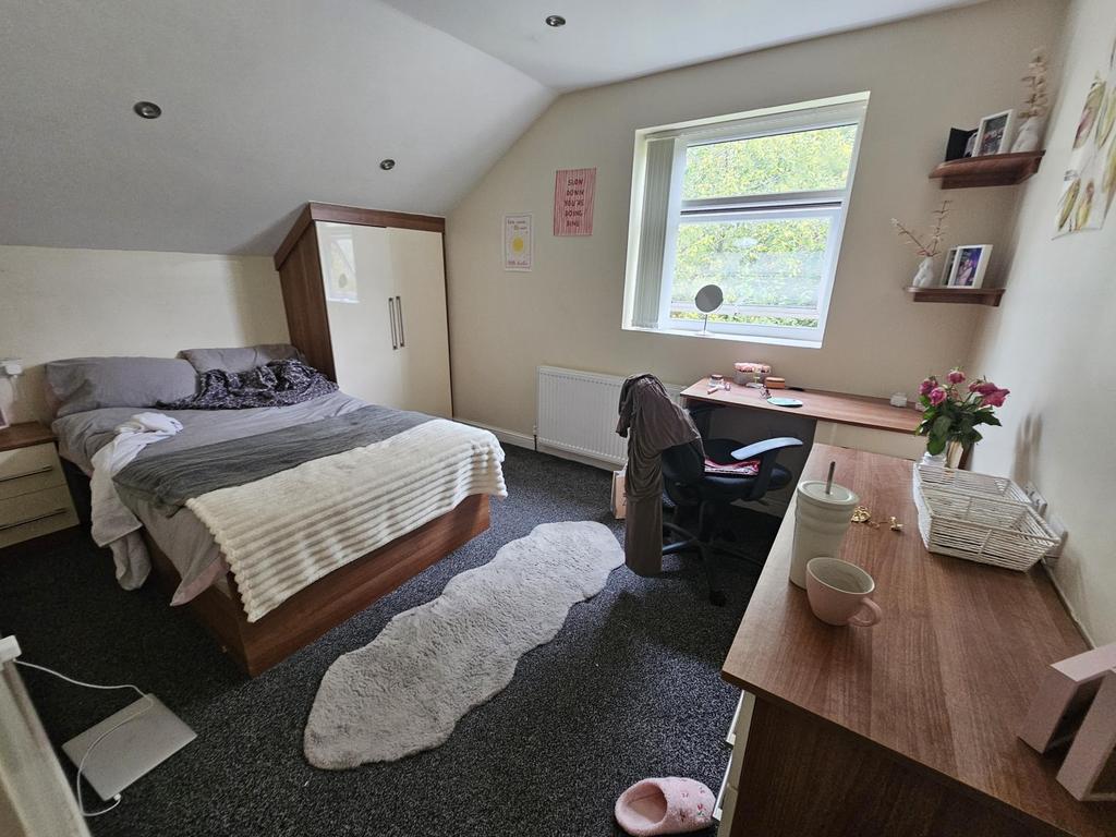 Spacious and well-lit bedroom featuring a comfo...