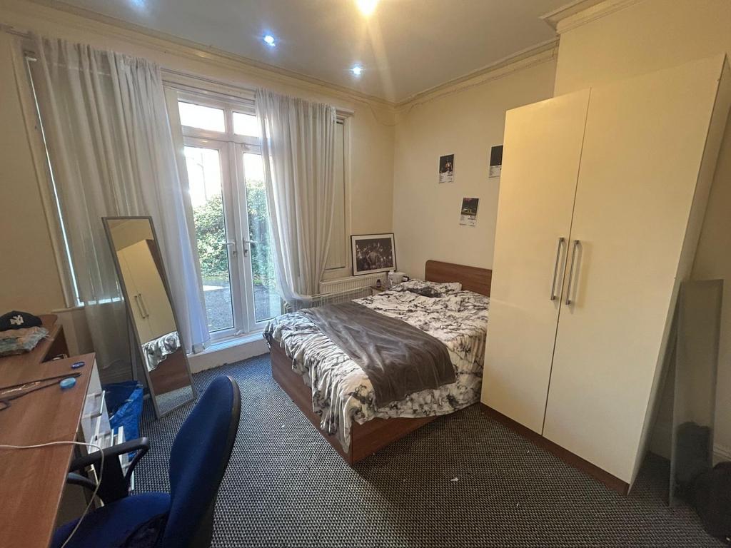 A well-lit double bedroom featuring a secure wa...