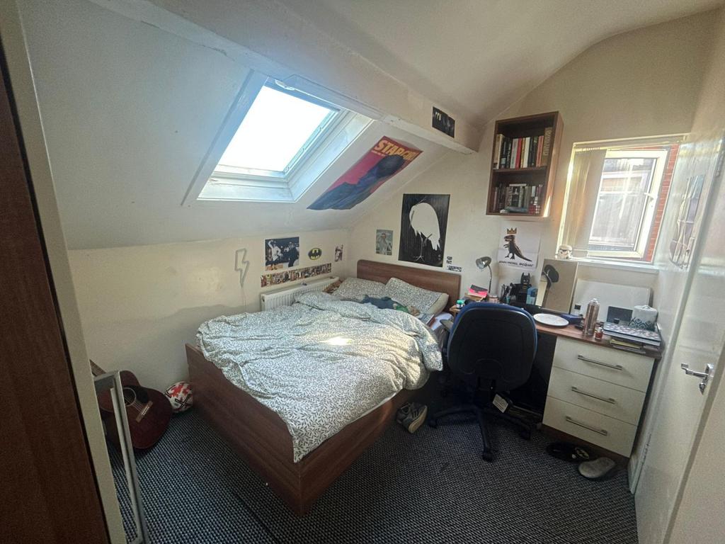 A bright and cozy bedroom featuring a large win...