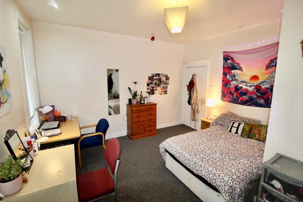 A bright and well-maintained bedroom featuring ...